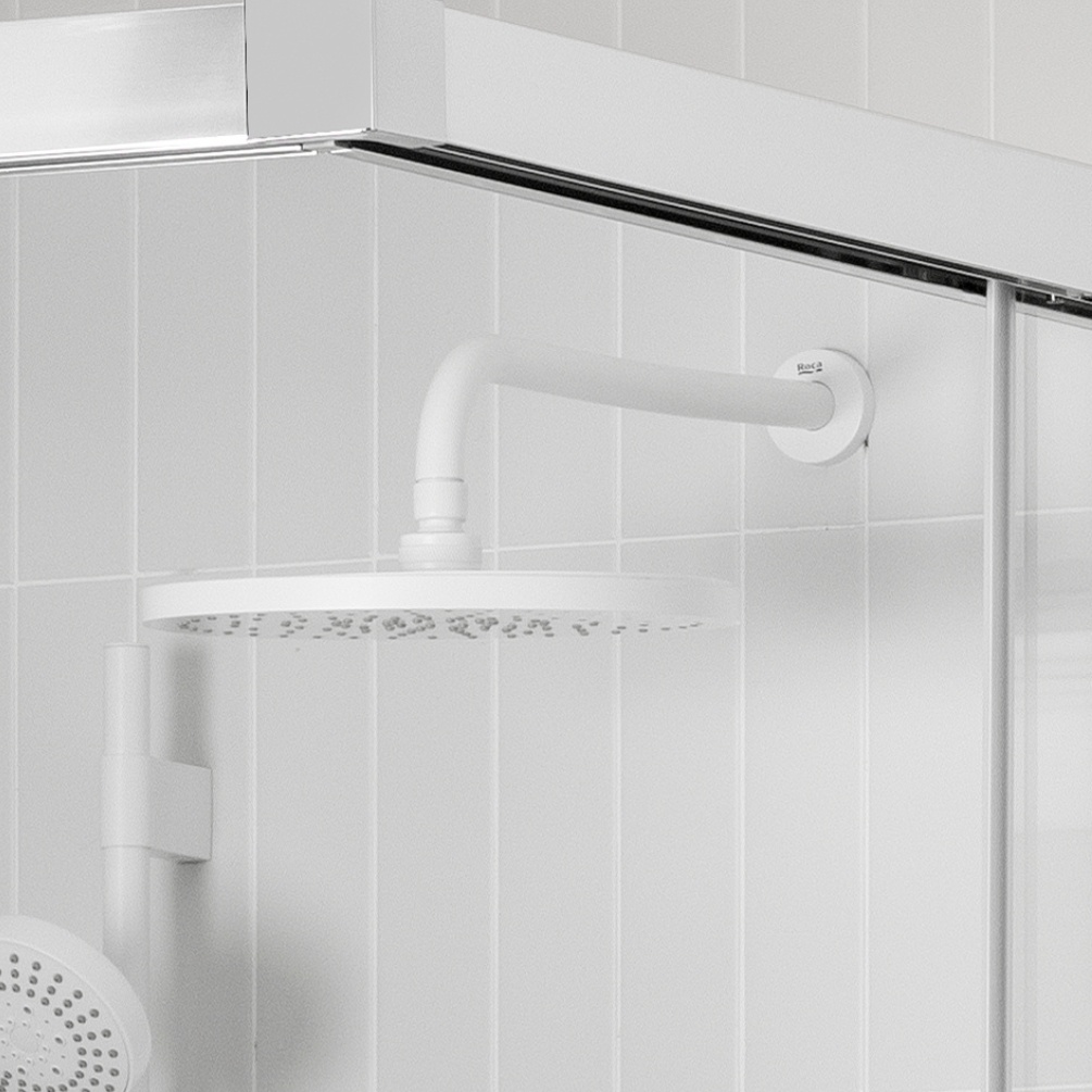 Lifestyle image of the Roca Matt White 400mm Round Wall Shower Arm mounted in a white shower enclosure with white round shower head